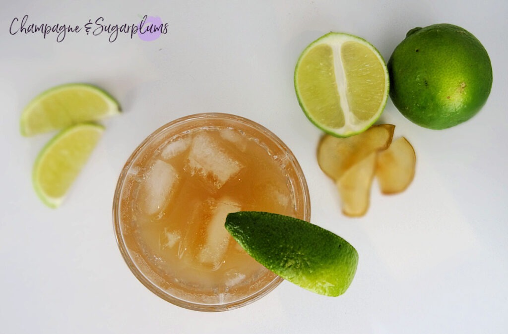The Teacher's Pet Back to School Cocktail pictured from above  on a white background with limes by Champagne and Sugarplums