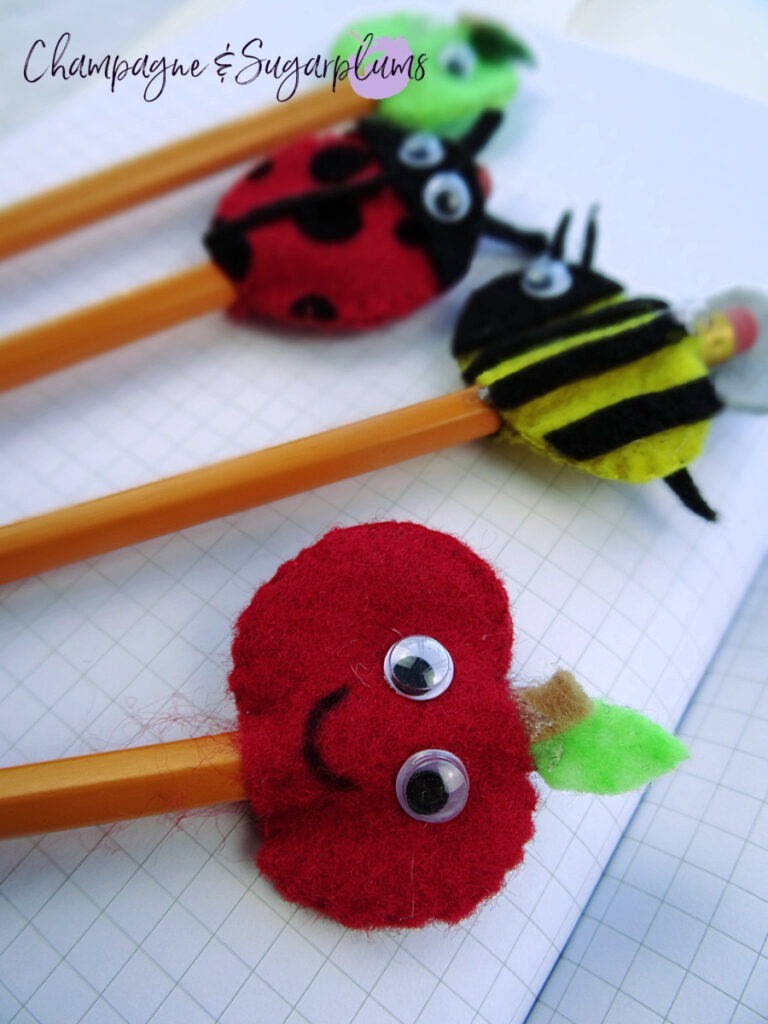 Felt Pencil Toppers - a green apple, red apple, bee and ladybug on a white grid paper background by Champagne and Sugarplums