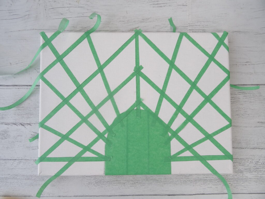 A geometric pattern taped in painters tape on a canvas by Champagne and Sugarplums