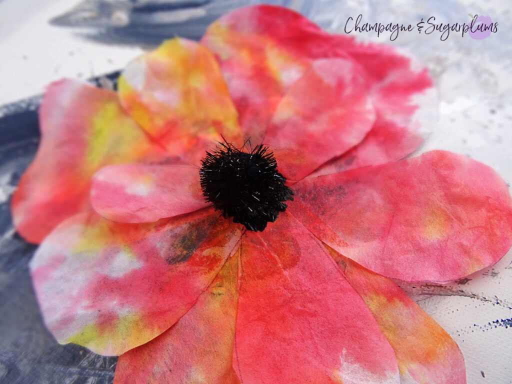 Gluing a pom pom onto a poppy by Champagne and Sugarplums