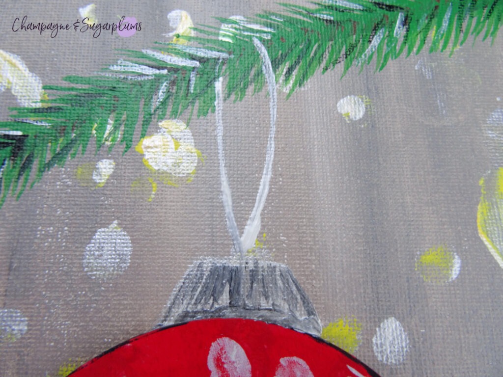 Painting an ornament string onto a painted branch by Champagne and Sugarplums